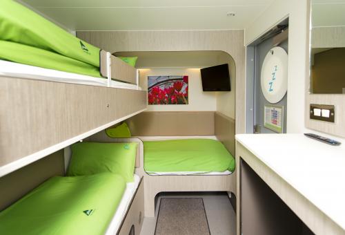 An interior view of the Eden Project accommodation rooms with bunk beds and green bedding